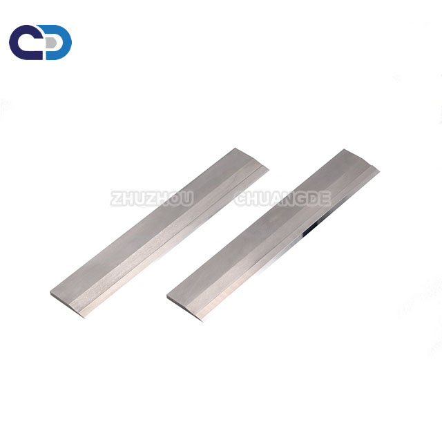 Cemented carbide strip scraper blade tips for conveyor cleaners